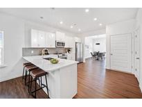 Modern kitchen with stainless steel appliances, a large island with seating, and sleek white cabinetry at 804 White St, Villa Rica, GA 30180