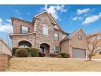 Charming two-story home featuring a stone and brick facade, arched entryway, and manicured landscaping at 4808 Albany Way, Atlanta, GA 30331