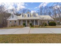 Beautiful brick home with a metal roof, dormer windows, and a large front yard at 550 Oak Ridge Dr, Oxford, GA 30054