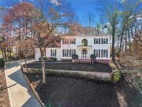 Charming two-story home features black shutters, a well-manicured lawn, and a classic front porch at 4324 Halifax Ne Ter, Roswell, GA 30075
