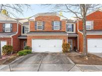 Charming brick townhome featuring a two-car garage and well-maintained landscaping at 6179 Bellewood Ash Ln, Tucker, GA 30084