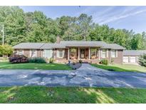 Charming single story brick home featuring an inviting front porch and well manicured landscaping at 4910 Pisgah Rd, Cumming, GA 30028