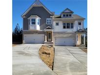 New construction two-story home with a two-car garage and a stone and gray shingle exterior at 201 Retreat Ln, Canton, GA 30114