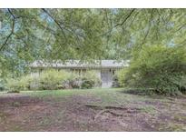 Charming single-story home with a brick facade surrounded by lush greenery and mature trees in a tranquil setting at 4068 Monticello Way, Atlanta, GA 30337