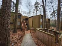 Condo with wood siding, exterior stairs, set in a wooded landscape at 5820 Par Four Ct, Lithonia, GA 30038