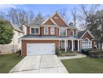 Charming brick two-story home with a two-car garage and beautifully landscaped front yard at 3388 Fieldwood Se Dr, Smyrna, GA 30080