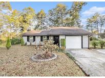 Charming single-story home featuring a well-maintained lawn, attached garage, and inviting front entrance at 2057 Bixler Cir, Decatur, GA 30032