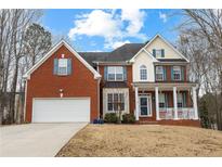 Charming two-story brick home featuring a two-car garage and inviting front porch at 130 Brookridge Ct, Fayetteville, GA 30215