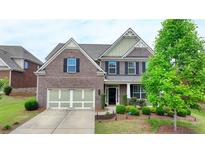 Charming two-story brick home with a well-manicured lawn and attached two car garage at 4340 Bluejay Pl, Cumming, GA 30041