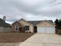 Charming single-Gathering home featuring stone accents and an attached two-car garage at 4976 Notting Glen Ln, Snellville, GA 30039