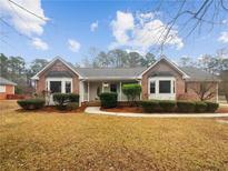 Charming brick home with well-manicured landscaping and inviting front porch at 180 Antebellum Way, Fayetteville, GA 30215
