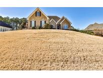 Charming brick home with a manicured front yard on a sunny day at 1137 Maple Creek Rdg, Loganville, GA 30052
