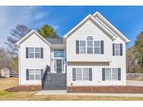 Charming two-story home featuring a white exterior, black shutters, landscaped yard, and inviting front porch at 80 Pooles Bend Ct, Hiram, GA 30141