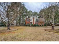 Charming two-story brick home with a well-maintained front lawn and mature trees at 500 Nicole Se Ct, Conyers, GA 30094