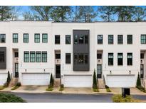 Modern townhome exterior with white painted brick, black trim, and attached garages at 2143 Druid Fields Ln, Decatur, GA 30033