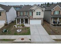 Charming two-story home featuring a landscaped front yard and a covered porch at 7266 Gladstone Cir, Lithonia, GA 30038