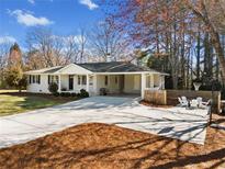 Charming renovated ranch home with a long driveway, well-manicured lawn and a cozy fire pit area at 970 Kennesaw Due West Nw Rd, Kennesaw, GA 30152