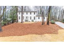 Charming renovated two-story home with a landscaped front yard and freshly painted white brick exterior at 5548 Martina Way, Atlanta, GA 30338