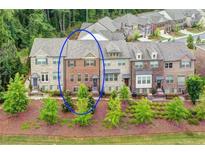 Attractive brick townhome with lush landscaping and inviting curb appeal in a desirable community at 5528 Cameron Parc Dr, Johns Creek, GA 30022