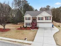 Inviting two-story home with a well-manicured lawn, classic shutters, and an attached two-car garage at 1100 Bradford Park Dr, Auburn, GA 30011