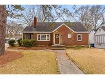 Charming brick home featuring a well-maintained lawn, inviting front door, and established landscaping at 1721 Clifton Se Way, Atlanta, GA 30316