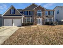 Charming two-story home featuring a two-car garage, stone accents, and a well-maintained lawn at 4906 Laythan Jace Ct, Snellville, GA 30039