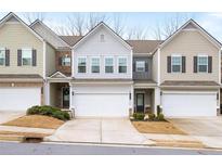 Townhouses with a nice lawn, driveway, and attached garages with multiple windows for natural light at 148 Inman Dr, Canton, GA 30114