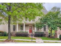 Charming two-story home boasts a covered porch, stone accents, and a lush landscaped front yard at 1624 Duncan Nw Dr, Atlanta, GA 30318