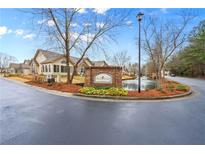 Silver Summit entrance features a brick sign, pond with fountain, landscaping and several well-maintained residential buildings at 302 Silver Summit Se Dr, Conyers, GA 30094