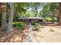 Charming brick home with a covered front porch and mature landscaping provides great curb appeal at 4138 Hickory Dr, Powder Springs, GA 30127