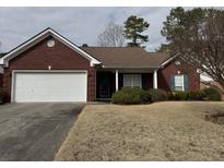Lovely brick home featuring an attached garage and well-maintained lawn at 2690 Freemans Walk Dr, Dacula, GA 30019