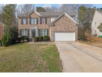 Charming two-story brick home featuring a two-car garage and manicured lawn at 4002 Forest Grove Nw Pass, Acworth, GA 30101