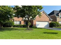 Charming brick home featuring a two-car garage, manicured lawn, and mature tree in front yard at 480 Glenns Farm Way, Grayson, GA 30017