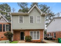 Charming two-story home with a brick facade, gray siding, and well-maintained landscaping at 4893 Autumn Cir, Stone Mountain, GA 30088