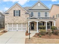 Charming two-story brick and siding home with an attached two-car garage and welcoming covered porch at 3650 Bentbill Xing, Cumming, GA 30041