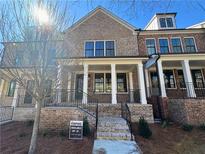 Attractive brick-front townhome features a covered entrance with sturdy columns and wrought iron railings on a landscaped lot at 1055 Dryden Ln # 10, Atlanta, GA 30319