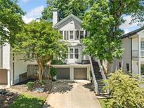 Charming home exterior with two-car garage, lush landscaping, and inviting stairway to upper level at 3232 Cates Ne Ave, Brookhaven, GA 30319
