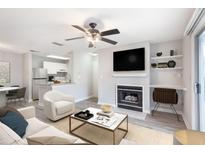 Bright living room with a fireplace, ceiling fan, and open floor plan flowing into the kitchen at 602 Granville Ct, Sandy Springs, GA 30328