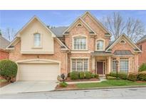 Charming brick two-story home with manicured front lawn and attached two-car garage at 1005 Brookhaven Ne Walk, Brookhaven, GA 30319