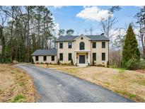 Charming two-story traditional home with a brick facade, dark trim, and a well-manicured front lawn at 805 Wesley Oak Rd, Atlanta, GA 30328