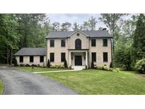 Beautifully landscaped front yard with well-manicured lawn and a classic two-story brick home at 805 Wesley Oak Rd, Sandy Springs, GA 30328