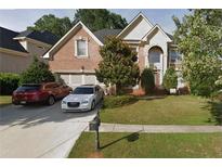 Charming two-story brick home with an arched entryway and a well-manicured front lawn at 3270 Moon Beam Ct, Snellville, GA 30039