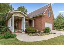 Charming brick home with a covered front porch and well-maintained landscaping at 180 Winecoff Dr, Fayetteville, GA 30214
