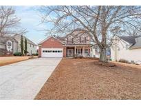 Charming two-story home with a brick facade, two-car garage and a well-manicured lawn, perfect for families at 730 Cloverwood Nw Ct, Lilburn, GA 30047
