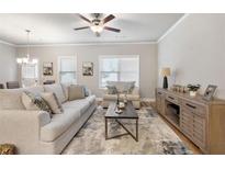 Bright living room featuring neutral tones, ceiling fan, and a comfortable seating arrangement at 253 Beau St, Lilburn, GA 30047