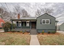 Charming single-Gathering home featuring a covered porch, dark green siding, and a well-maintained landscaped front yard at 4131 Carroll Sw St, Covington, GA 30014