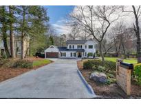 Charming two-story white home with dark shutters and an extra-long driveway at 3090 Maple Ln, Alpharetta, GA 30009