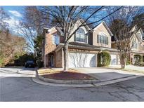A charming brick and siding townhome boasts a two-car garage and inviting curb appeal at 3263 Tomeh Way, Tucker, GA 30084