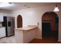 Cozy kitchen featuring stainless steel appliances and a breakfast bar overlooking an arched doorway and hardwood floors at 3736 Soapstone Rd, Decatur, GA 30034