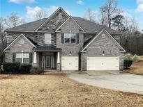 Charming two-story brick home with a well-manicured lawn and a two-car garage at 405 Sora Dr, Stockbridge, GA 30281